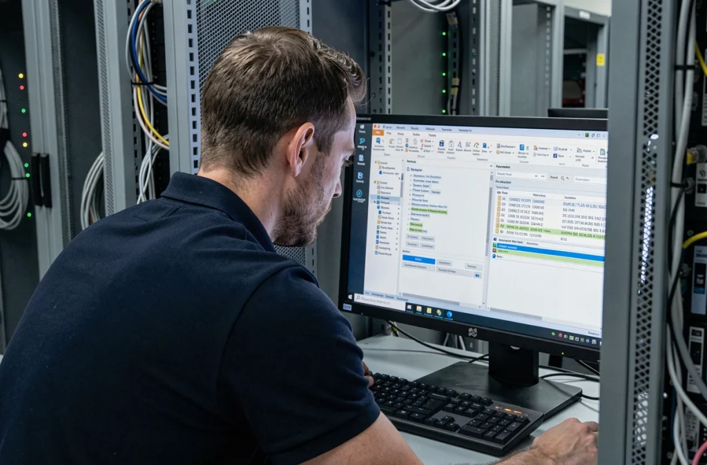 Technicien informatique analysant les logs d'erreur du protocole PIX de réception courrier dans une salle serveur